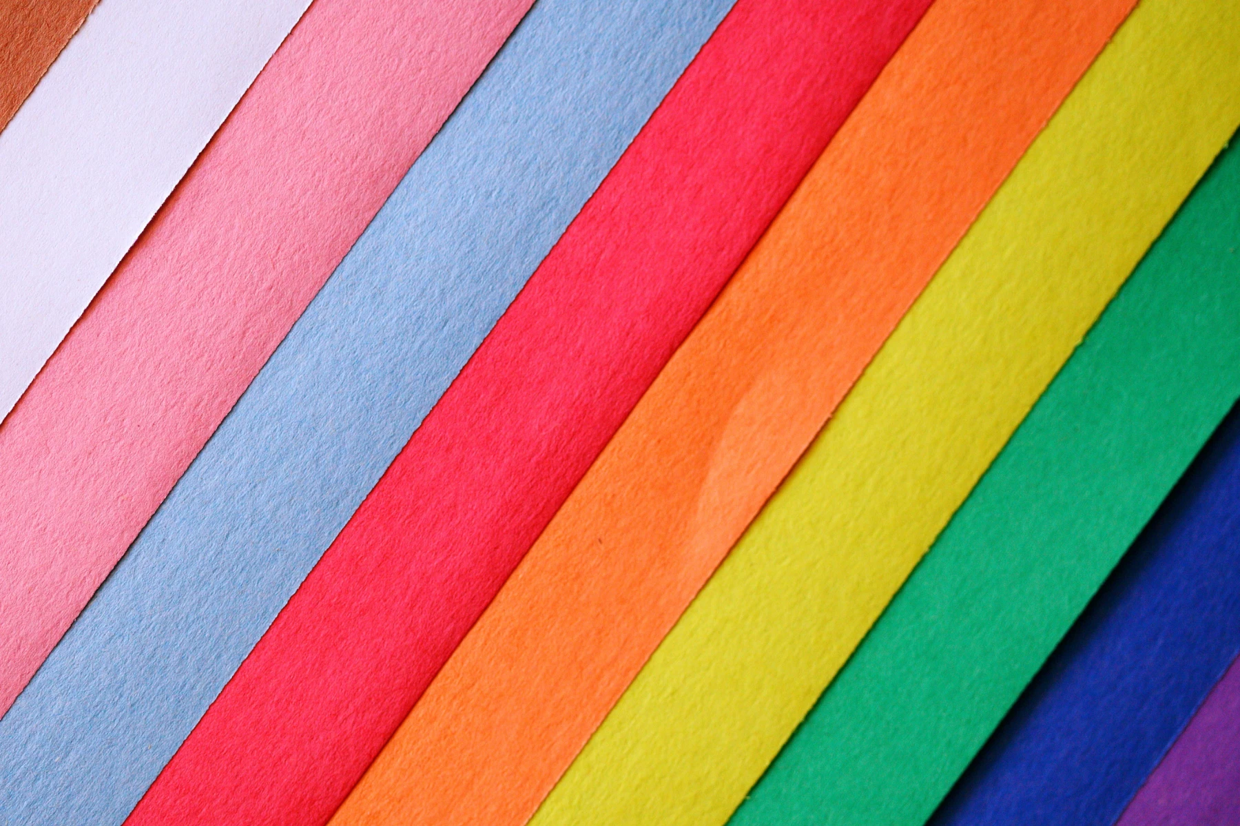 Strips of coloured paper fanned out in pink, blue, red, orange, yellow, green and purple